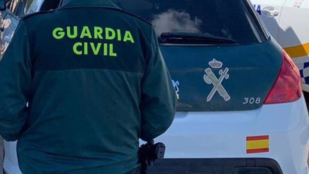 ep archivo   un agente de la guardia civil de espaldas y junto a un vehiculo oficial del cuerpo