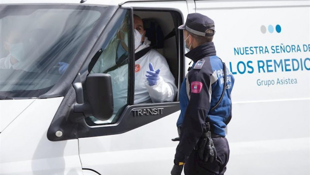 ep dos trabajadores de una funeraria que visten totalmente protegidos llevan los primeros cuerpos al