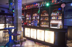 ep un trabajador prepara una copa en la barra de un bar vacia