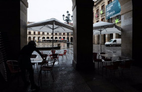 ep una persona limpia una mesa en una terraza de un establecimiento de vitoria