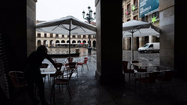 ep una persona limpia una mesa en una terraza de un establecimiento de vitoria