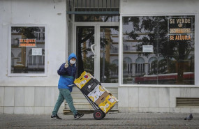 ep un trabajador realiza el reparto protegido con una capucha bajo la lluvia en la quinta semana del