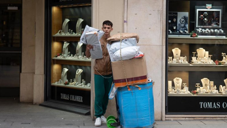 ep archivo   un joven repartidor se apoya junto a cajas con compras durante la campana de navidad