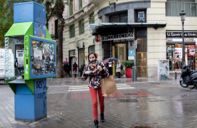 ep una chica pasea por la calle abrigada con bufanda y abrigo durante el peor temporal del otono del