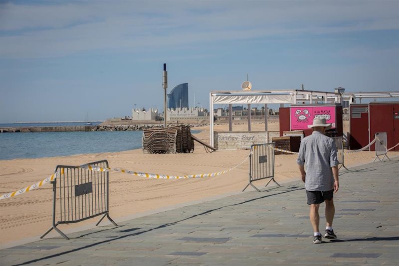 https://img.s3wfg.com/web/img/images_uploaded/e/e/ep_un_hombre_pasa_junto_a_la_base_nautica_de_la_playa_del_bogatell_en_barcelona_espana_a_7_de_mayo.jpg