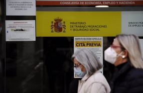 ep archivo   dos mujeres pasan por la puerta de una oficina de empleo
