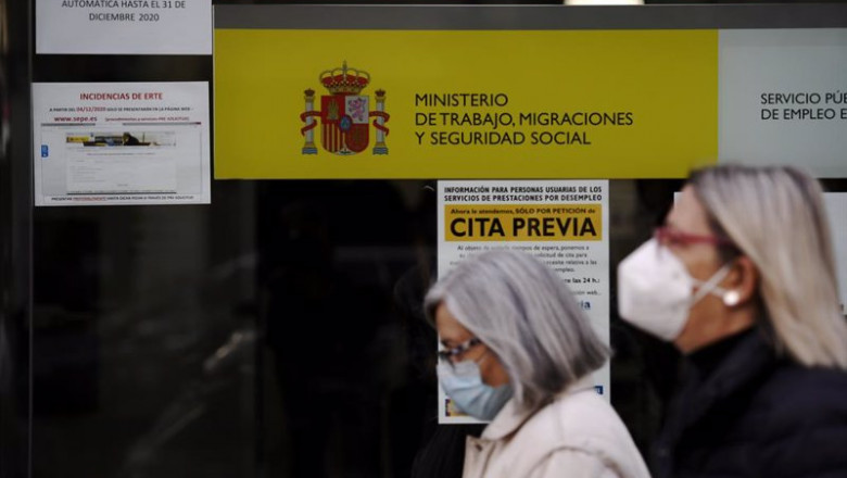 ep archivo   dos mujeres pasan por la puerta de una oficina de empleo