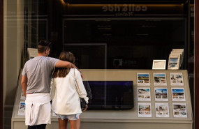ep archivo   dos personas observan los anuncios de viviendas en venta en una inmobiliaria