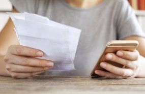 ep archivo   persona sujeta un telefono y una factura