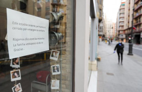 ep cartel en la ventana de un establecimiento cerrado en una calle practicamente vacia durante el