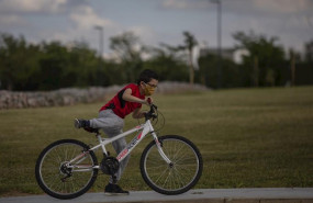 ep un nino protegido con mascarilla monta en bicicleta en el tercer dia de desconfinamiento de ninos