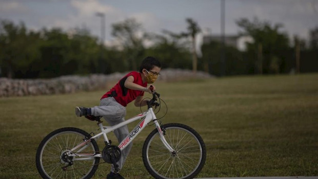 ep un nino protegido con mascarilla monta en bicicleta en el tercer dia de desconfinamiento de ninos