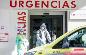ep un sanitario empuja una silla de ruedas con un enfermo leve de covid-19